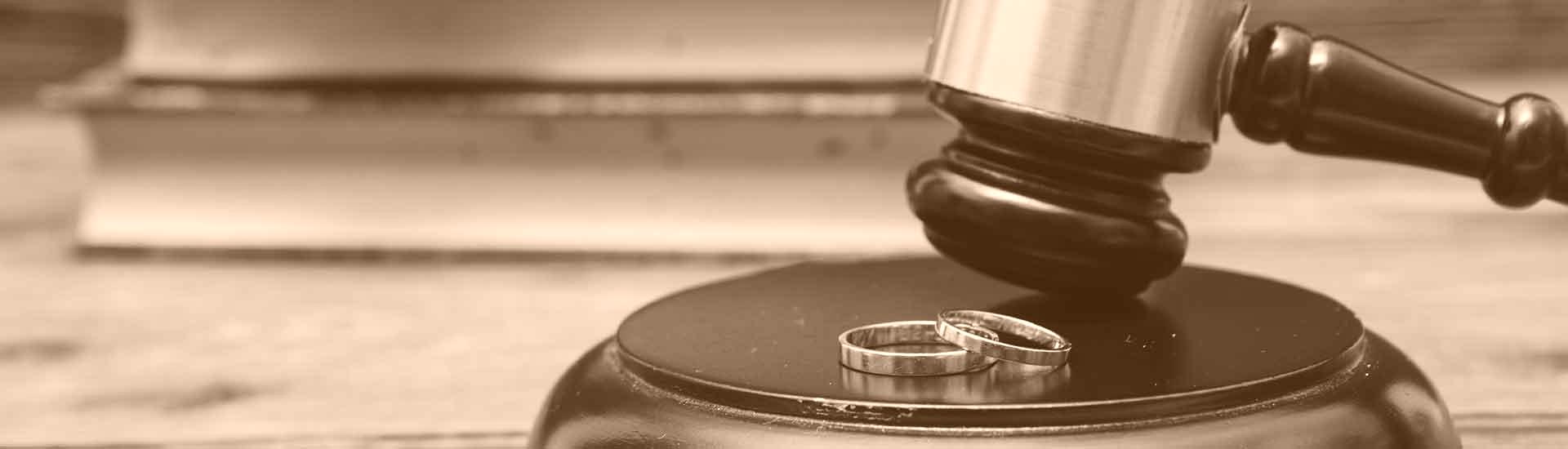 judges gavel next to two wedding rings