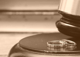 judges gavel next to two wedding rings